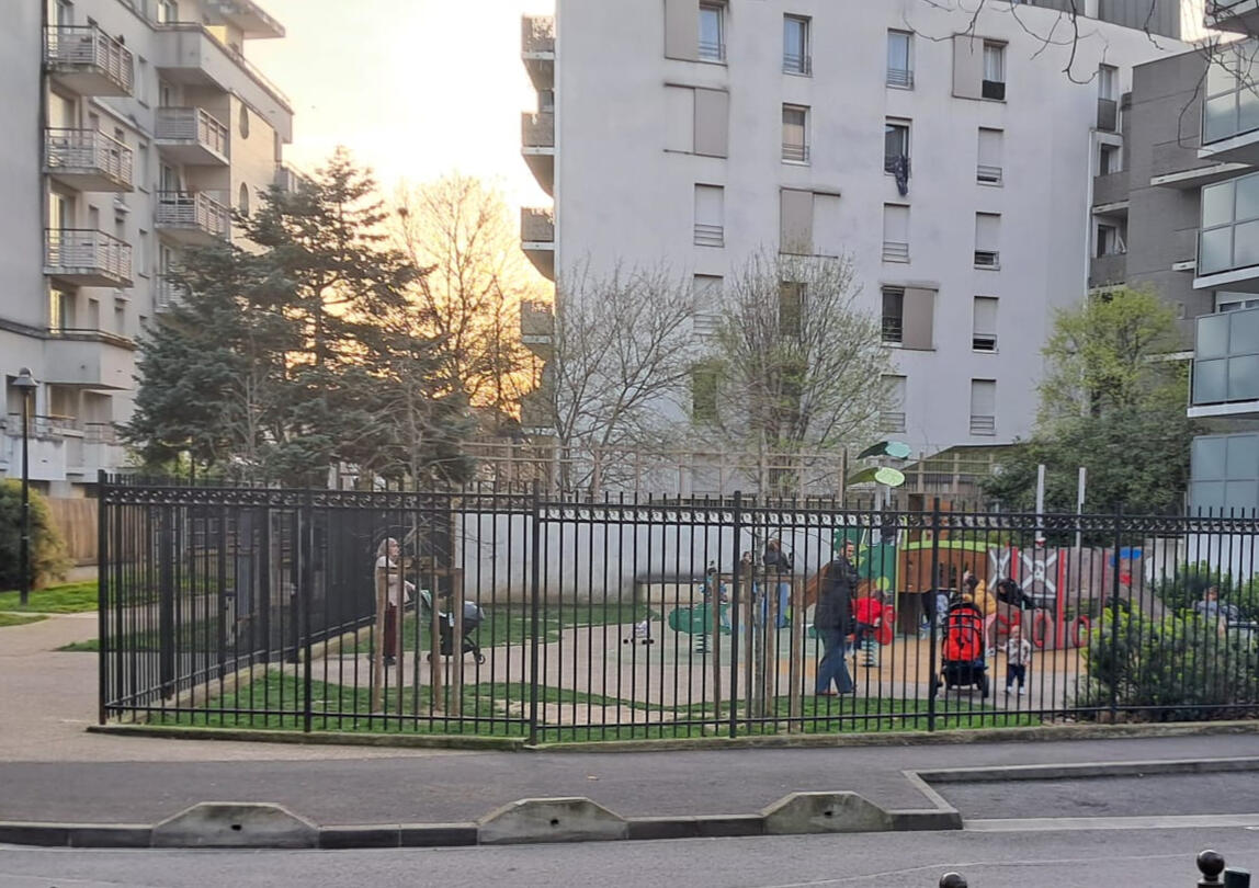 Photo du Square Martine Ondet, qui montre une aire de jeux étroite et entourée de grilles.