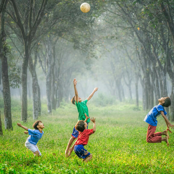 Photo d'enfants jouants au ballon en plein air.