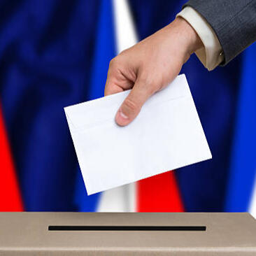 Photo d'illustration d'une main déposant un bulletin de vote dans une urne.